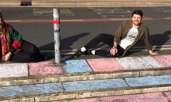 LGBTQ+ officers sitting on steps smiling